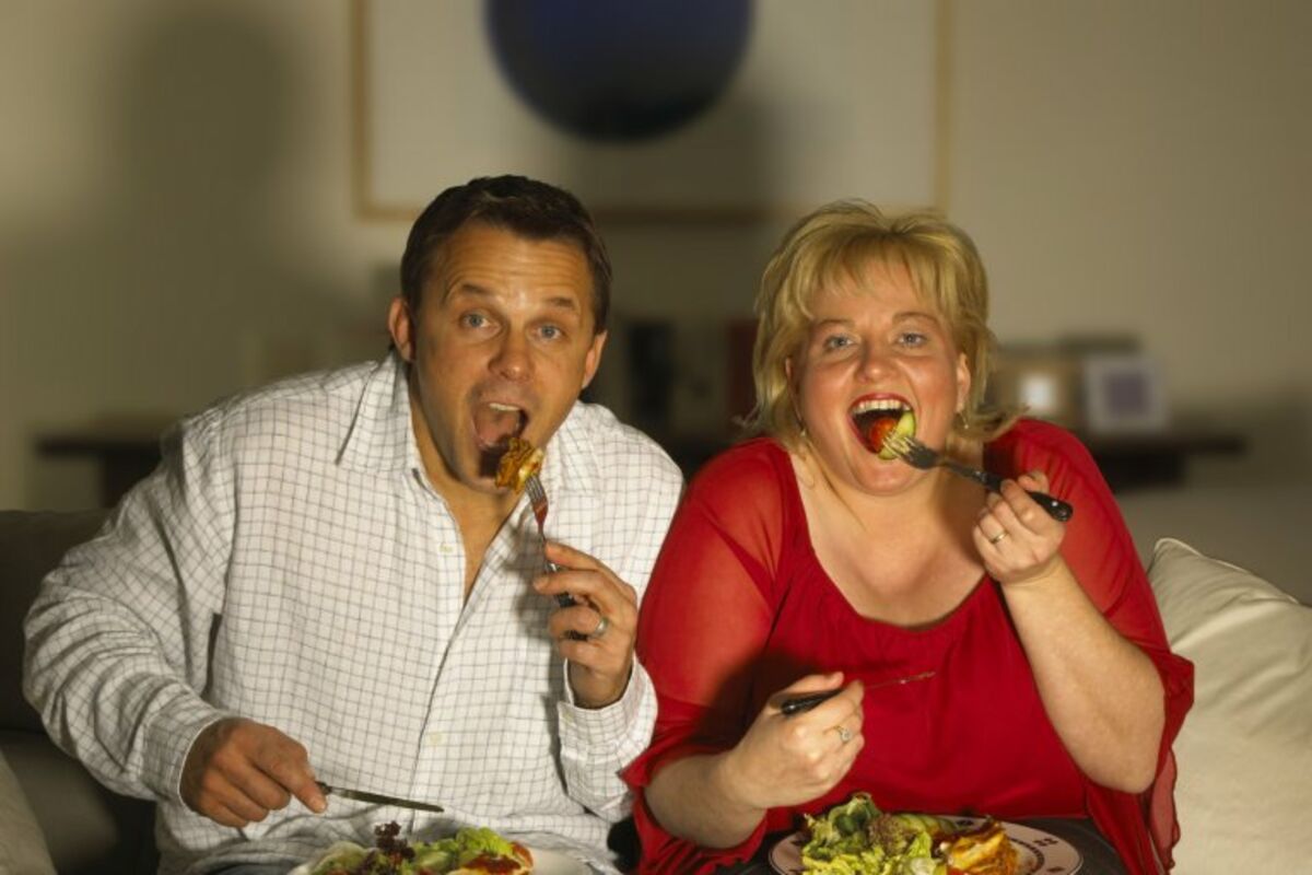 Семейное толстая жена. Толстушка с едой. Еда перед телевизором. Полные люди едят. Толстый человек с едой.