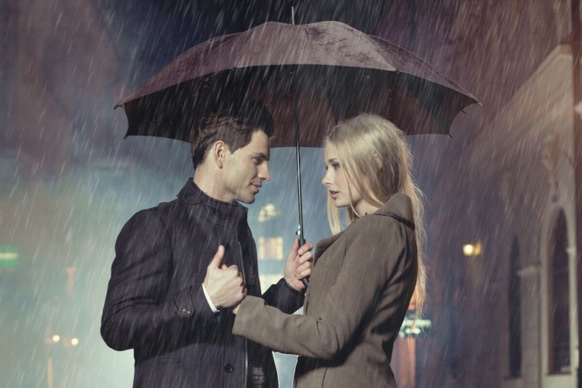 Там живут двое. Мужчина и женщина под зонтом. Парень и девушка под зонтом. Двое под дождем. Под одним зонтом.