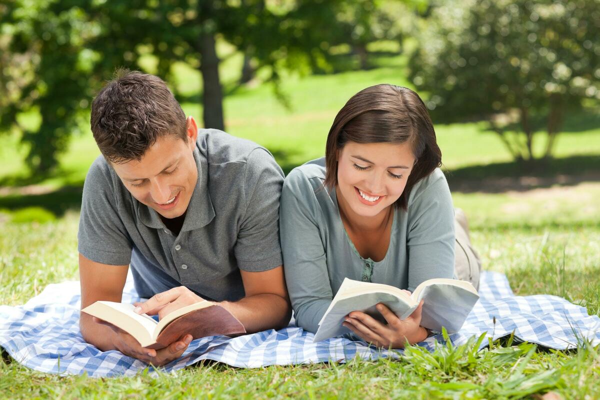 Том читает и смеется. Молодежь и книга. Парень и девушка читают книгу. Пара читает книгу. Молодая пара с книгами.